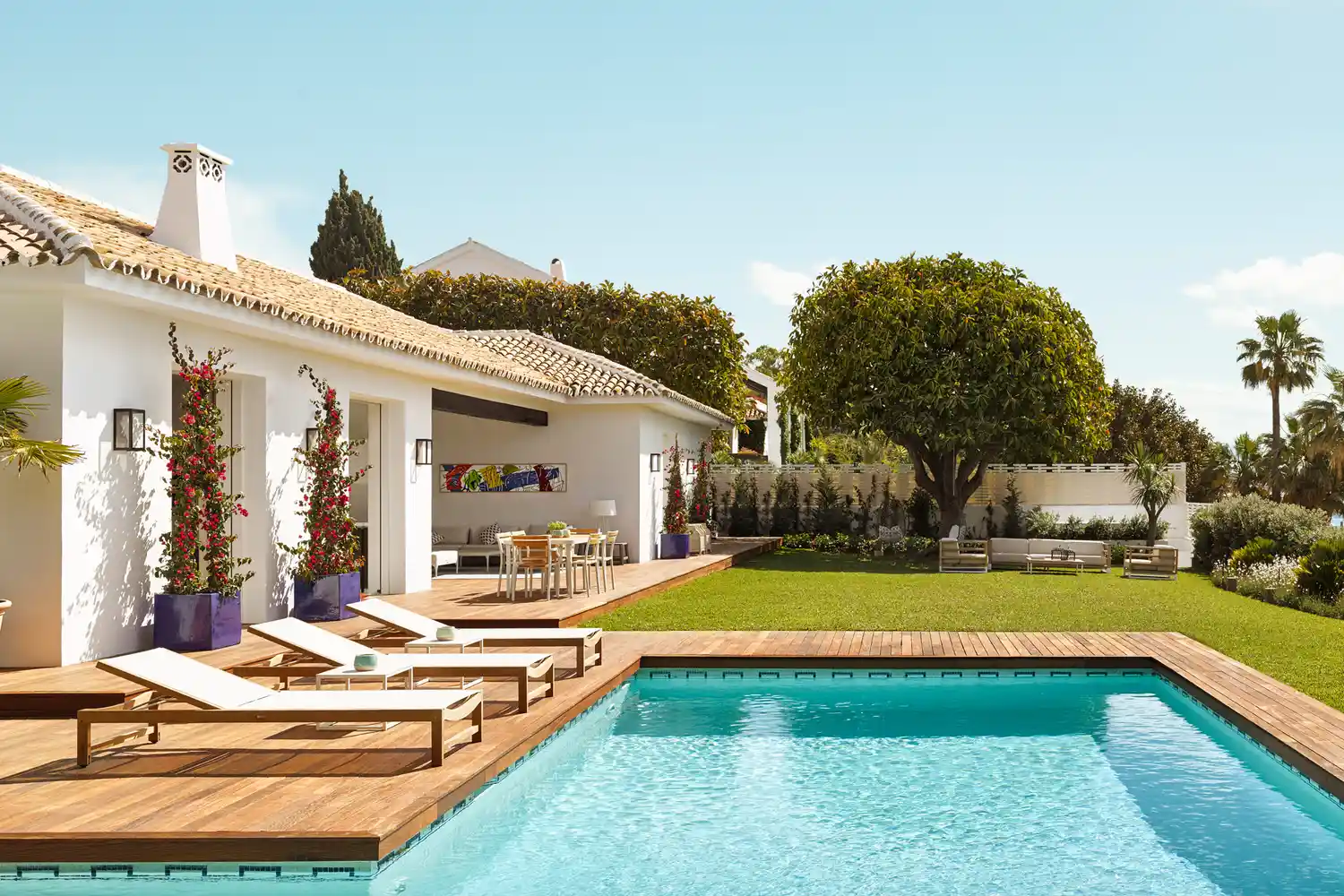 A luxury villa with a turquoise swimming pool and lush manicured gardens at Hotel Puente Romano.