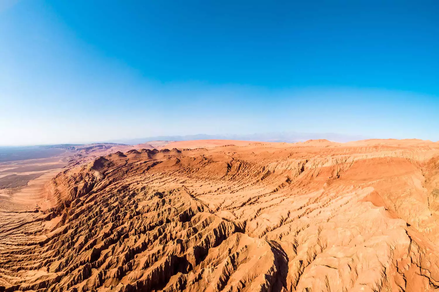 Eroded red sandstone hills of the Flaming Mountains in Xinjiang, China.
