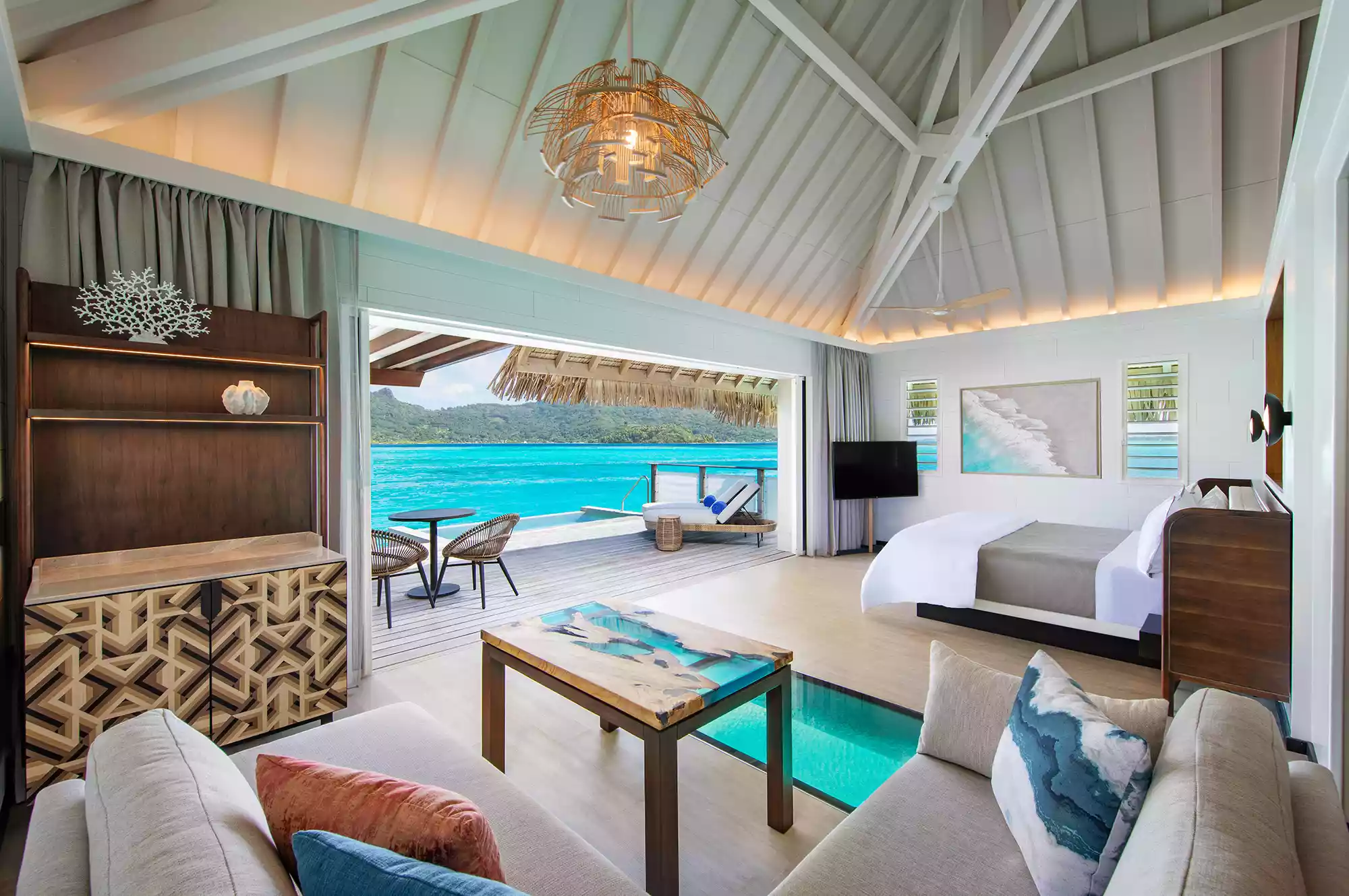 Modern luxury bedroom interior in a Westin Bora Bora overwater bungalow.