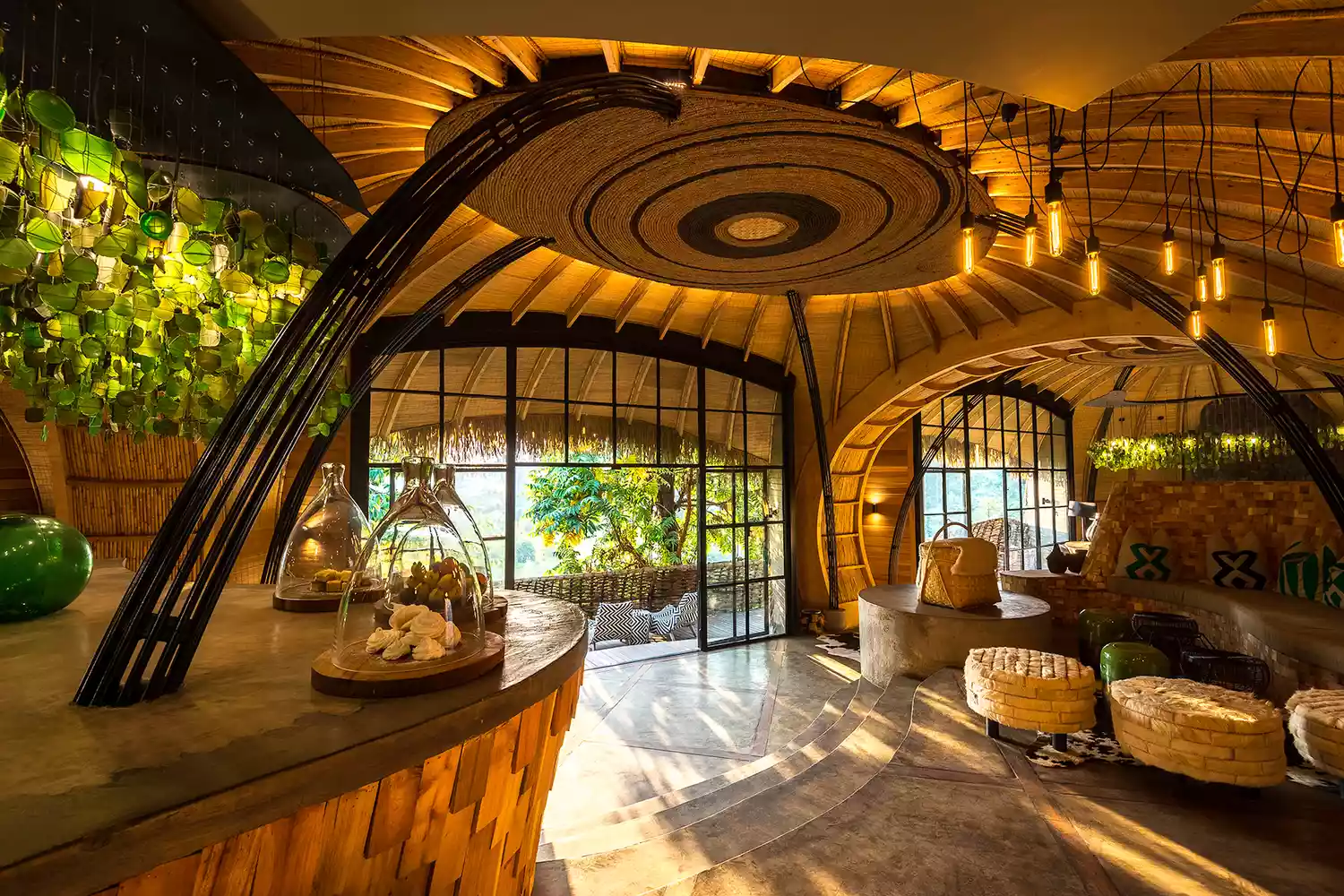 Modern interior of a common space at Wilderness Safaris Bisate Lodge with rounded wooden architecture.