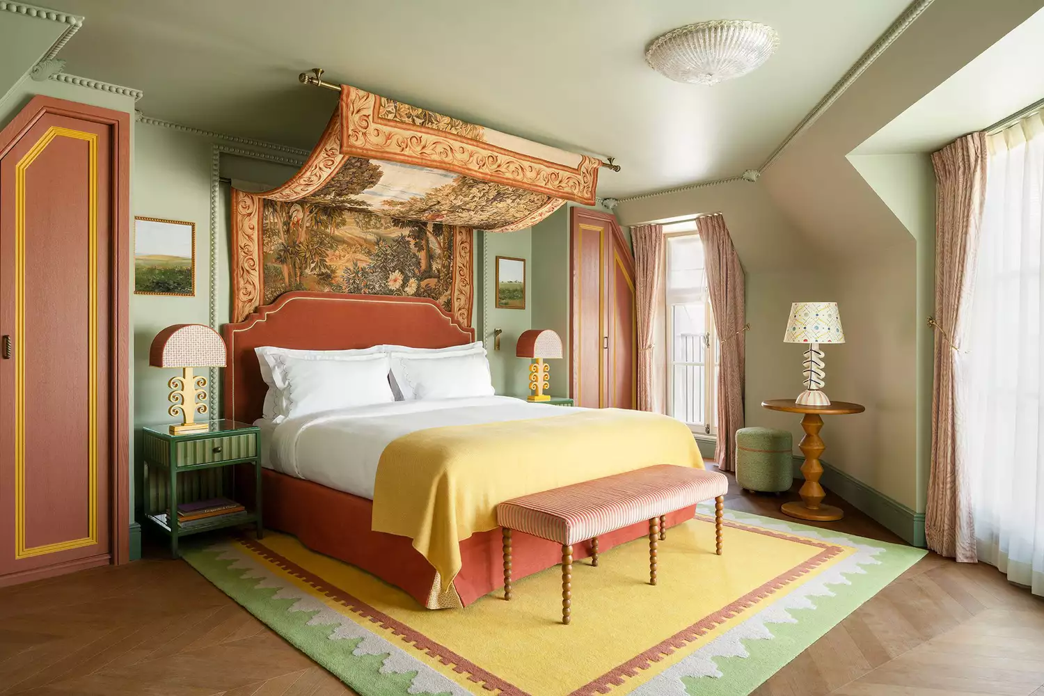 The opulent bedroom of a Grande JS Parisienne suite at Le Grand Mazarin featuring bold patterns and elegant furnishings.