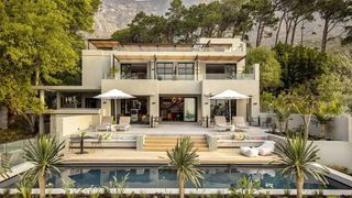 A luxury villa terrace featuring an infinity pool and modern outdoor furniture overlooking the ocean.
