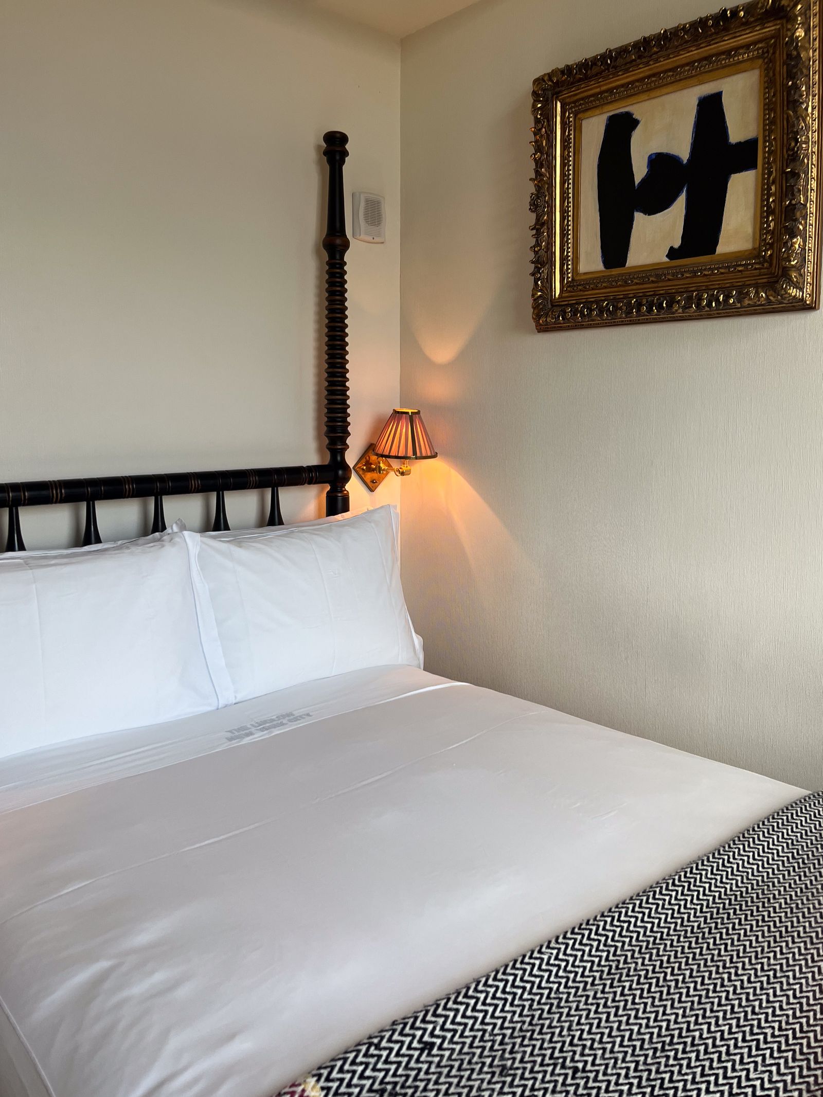 Interior of a Skybox Loft guest room at The Ludlow Hotel featuring a large bed and plush decor.