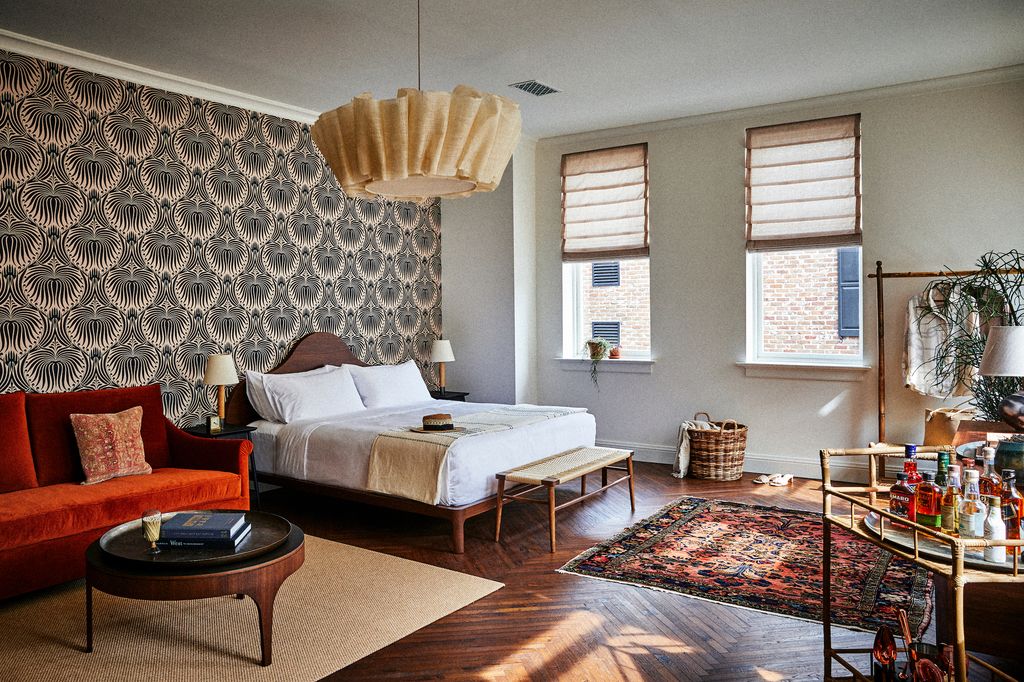 The interior of a suite at The Pinch featuring mid-century modern furniture, a large rug, and artistic lighting.