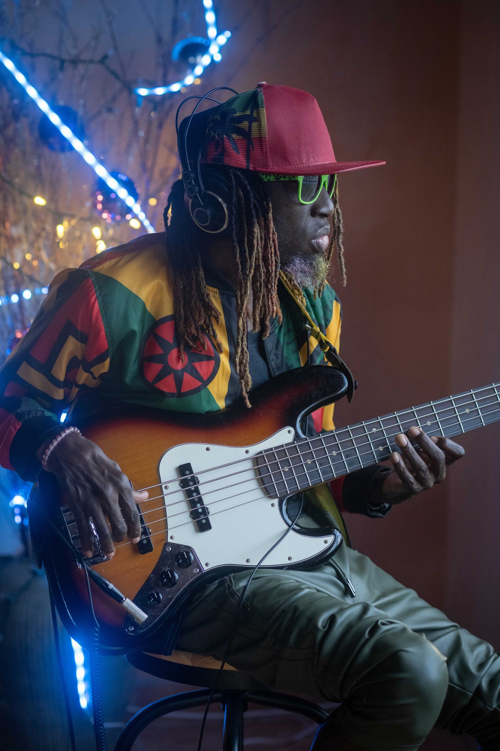 A performer playing a guitar in a relaxed outdoor setting.