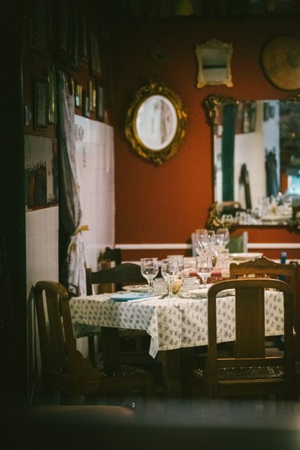 A well-appointed dining room in a Lisbon restaurant with white tablecloths and classic furniture.
