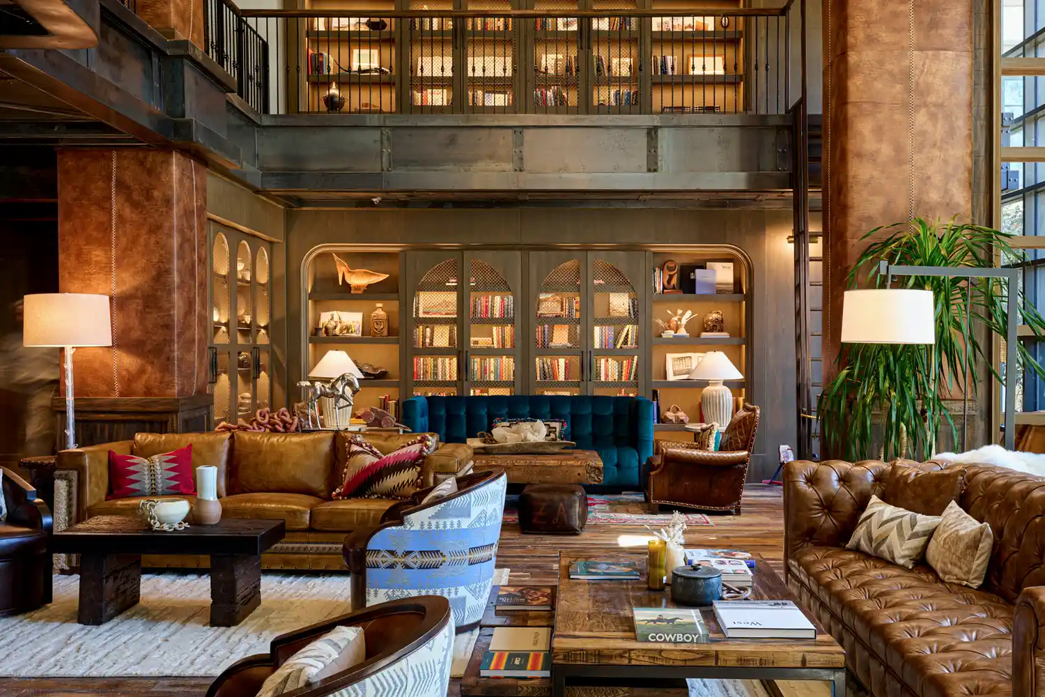 A rustic luxury lounge with leather seating and built-in bookshelves at Hotel Drover.