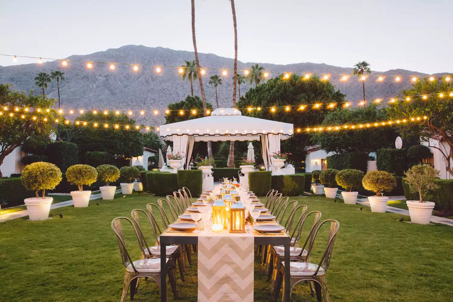 A manicured outdoor courtyard patio at Avalon Palm Springs with manicured hedges.