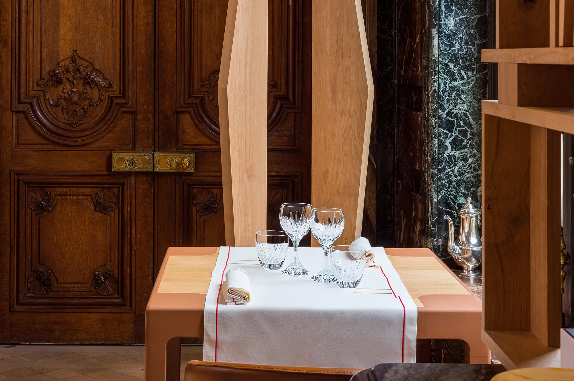 An intimate dining table at Ducasse Baccarat with crystal glassware and elegant decor.