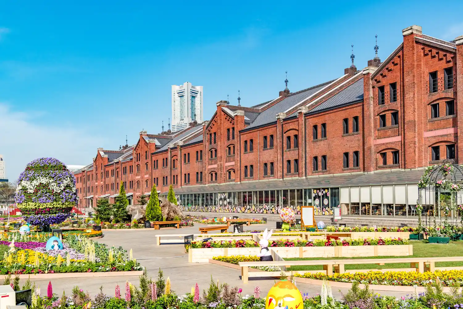 The historic red brick facade of the Yokohama Red Brick Warehouse under a clear sky.