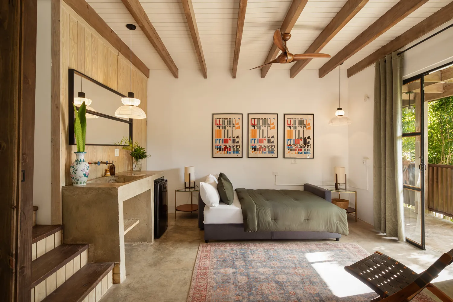Modern bedroom with wood accents and a glass door opening to a private garden area.