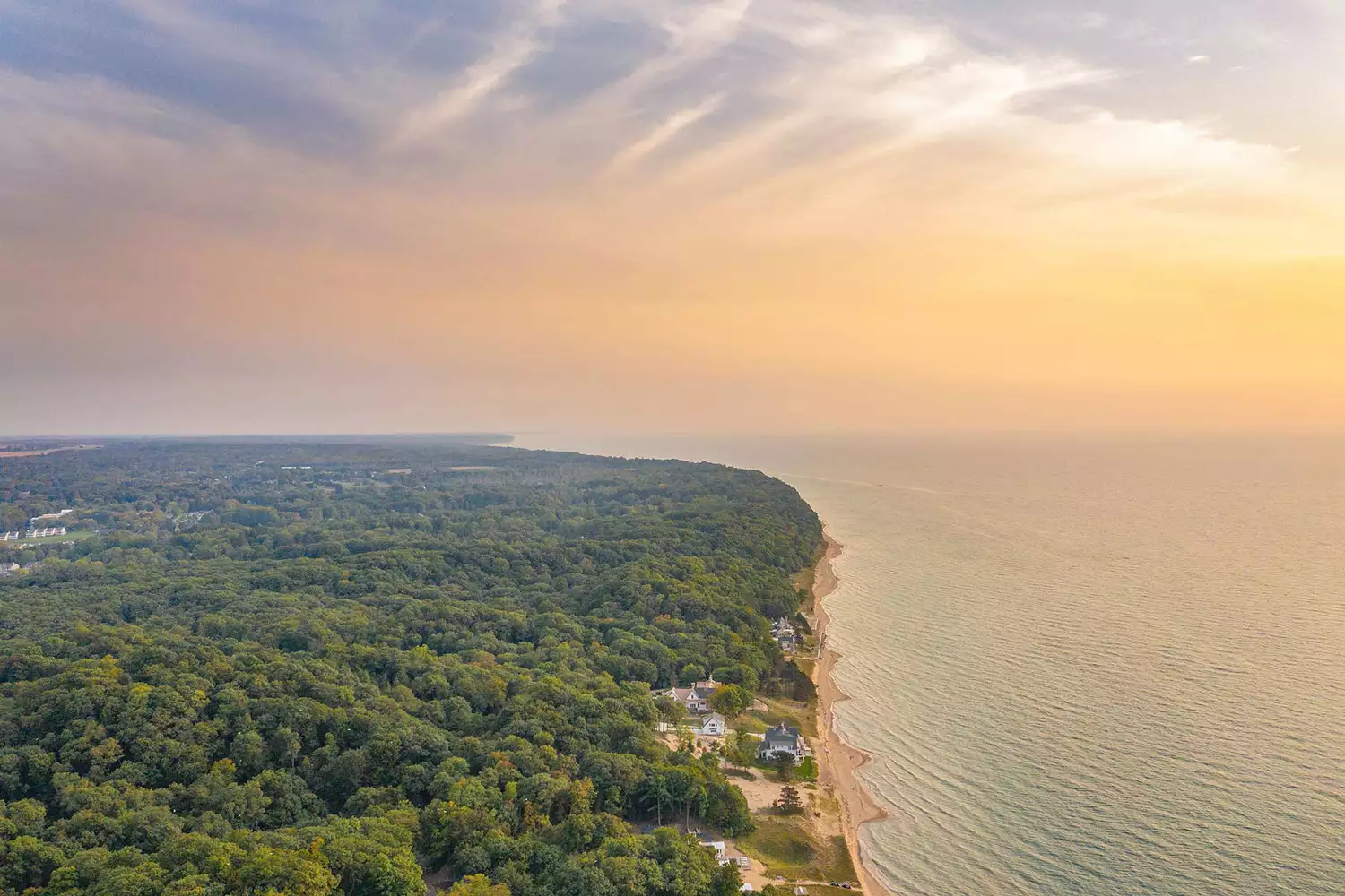 Sunset aerial view of the golden sandy beaches and rolling dunes surrounding Saugatuck.