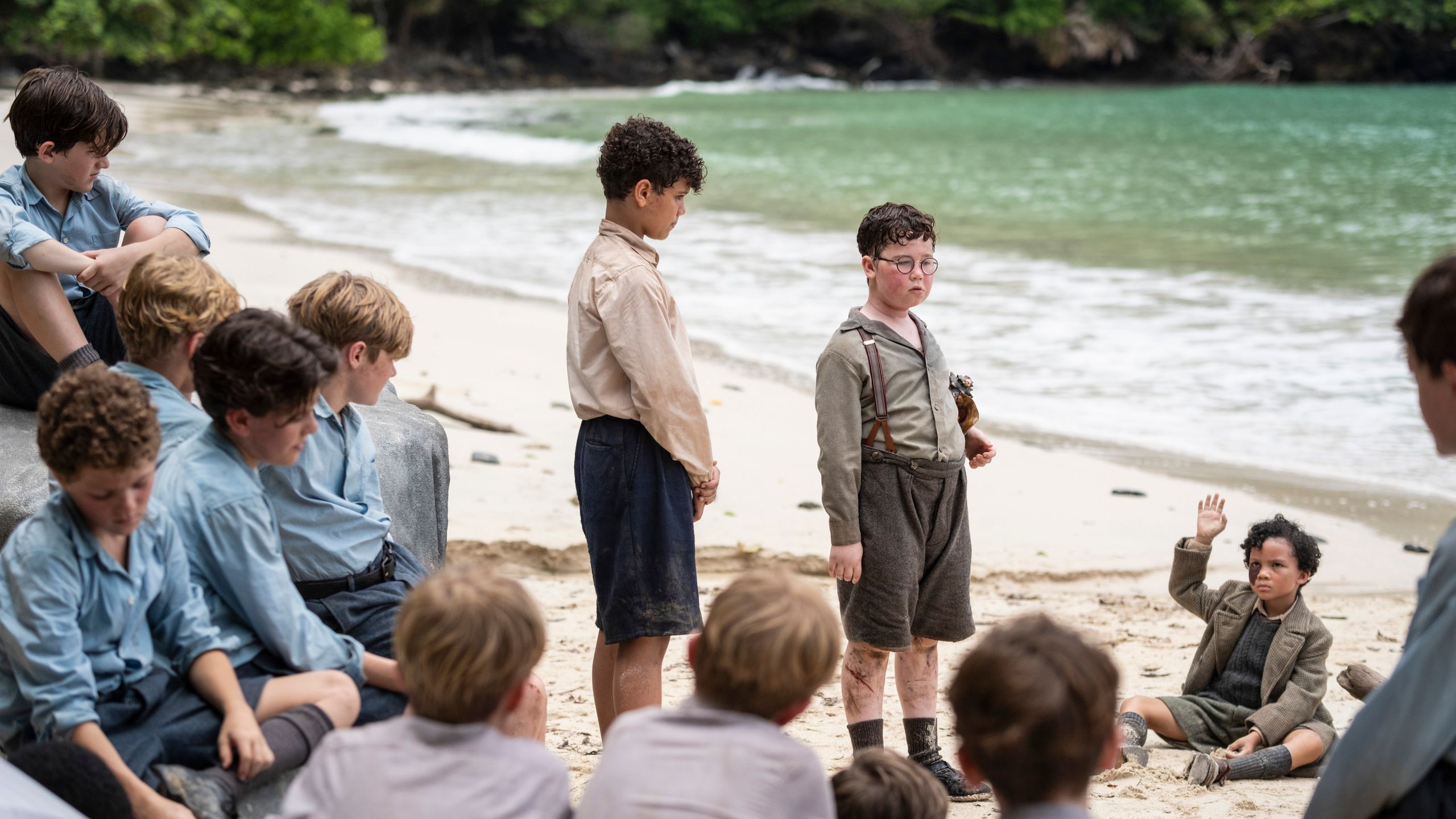 A child in schoolhouse-style clothing and glasses looking forward.
