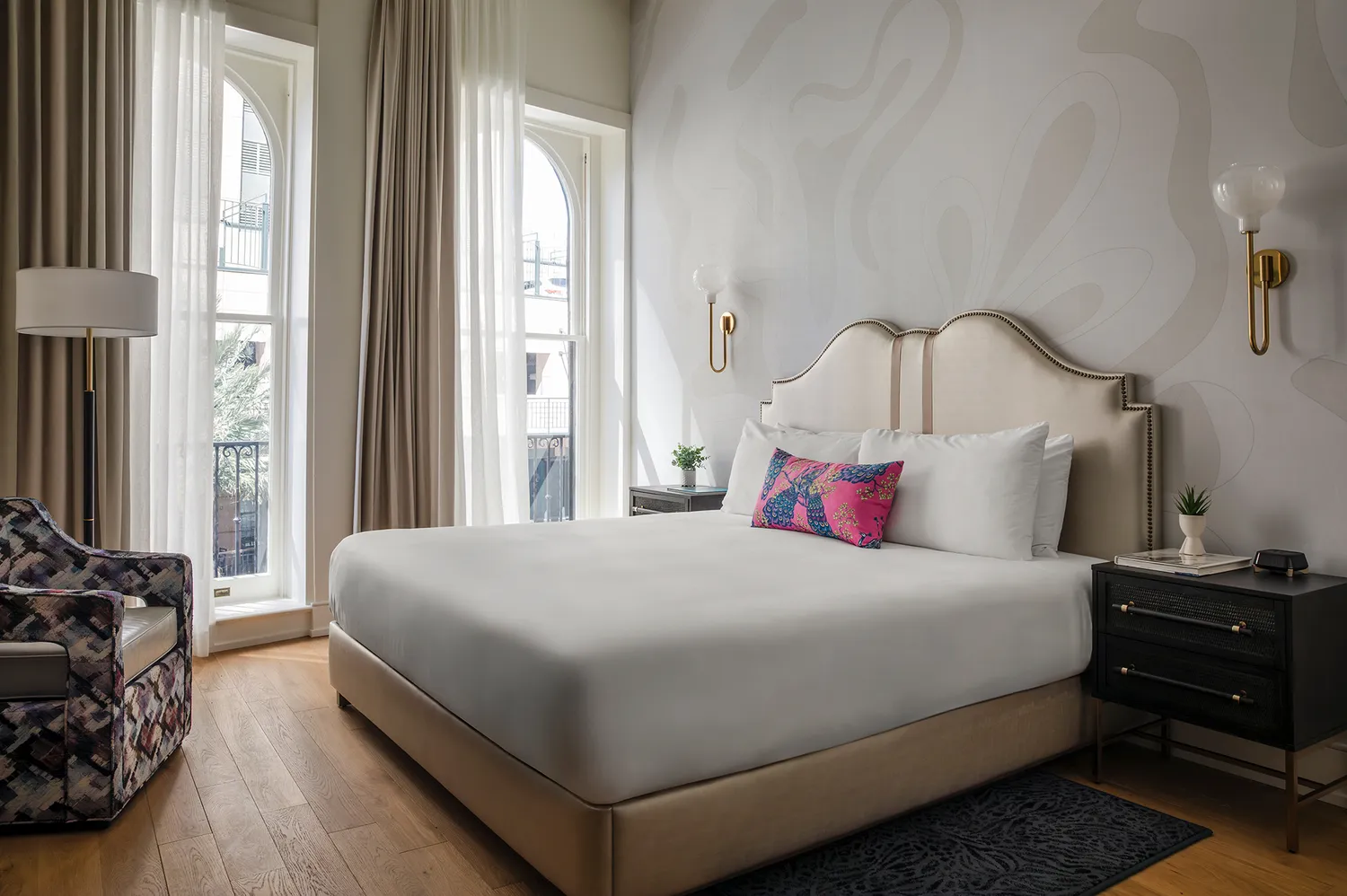 A King guest room at The Monarch with high ceilings and large windows.