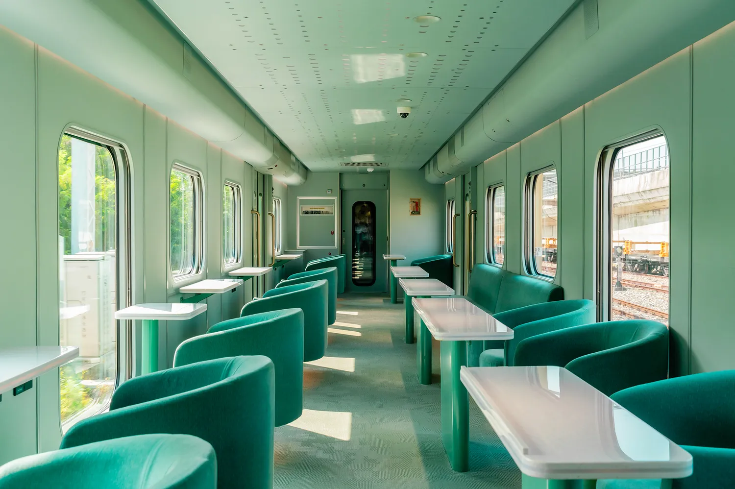 Interior lounge car of the Haifeng train featuring sea-facing sofa seating.