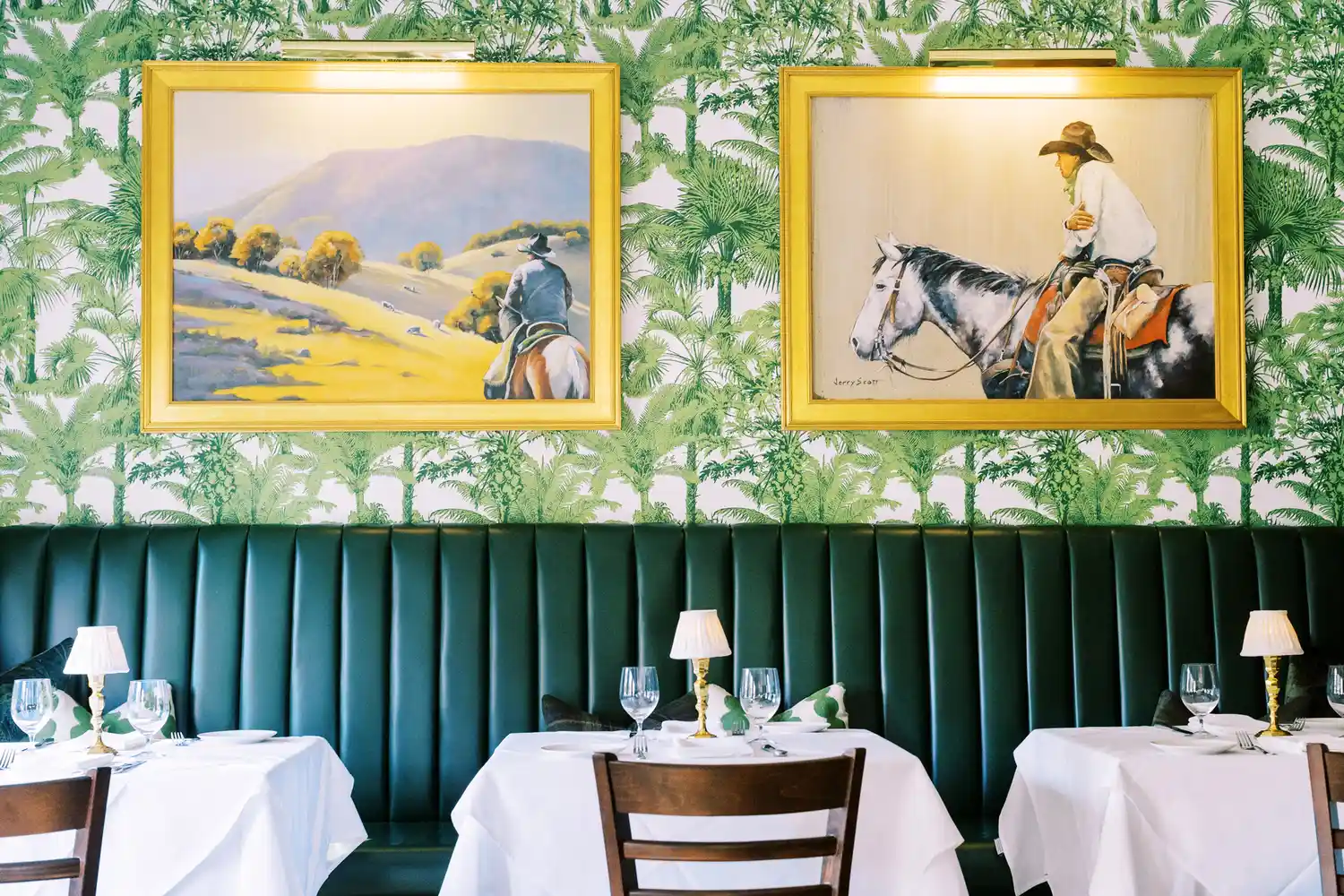 Interior of Nate's on Marsh restaurant featuring white linen tables and Western-themed artwork.