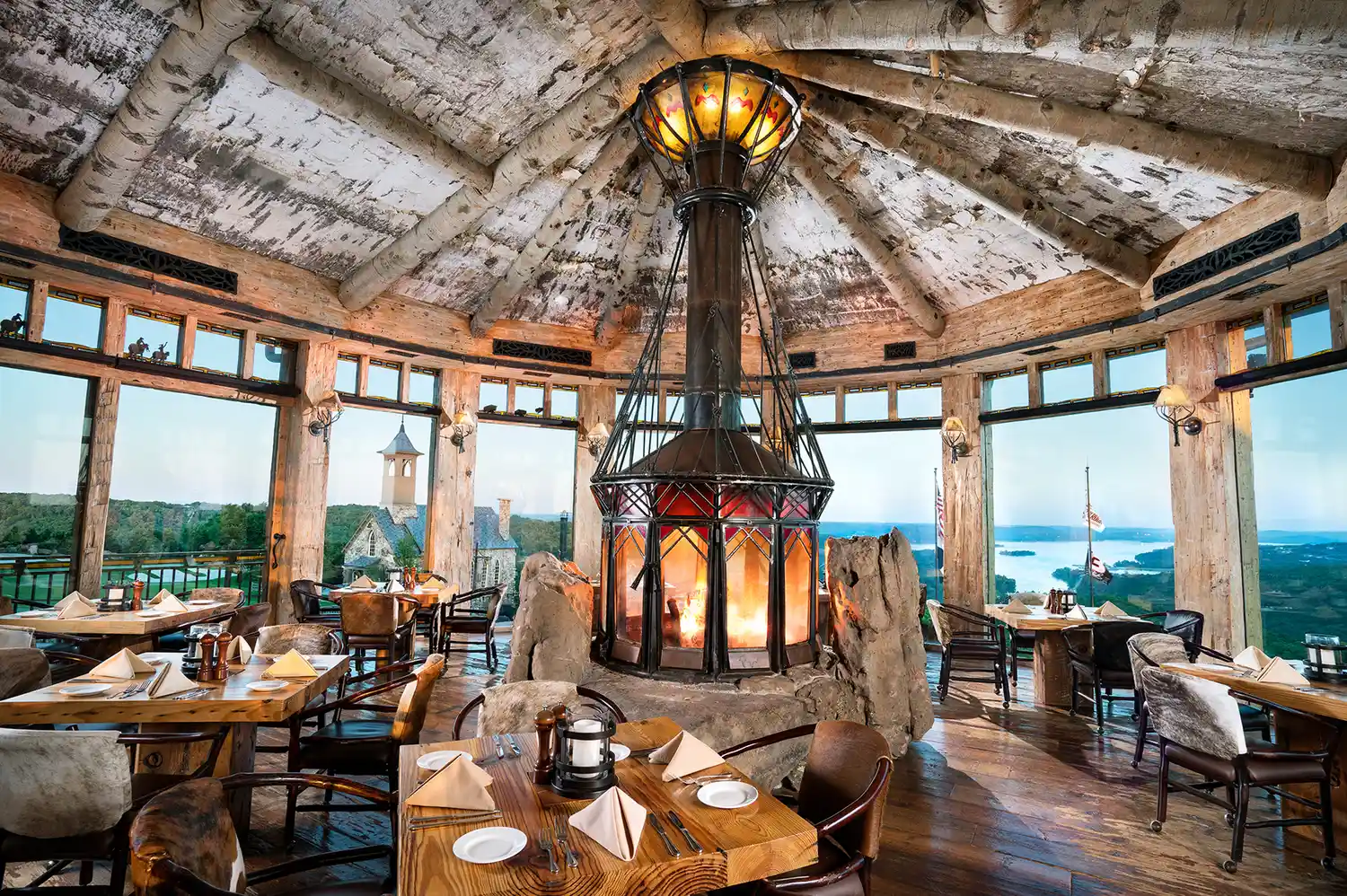 The interior of the Osage Rotunda Room with large windows and a central stone fireplace.