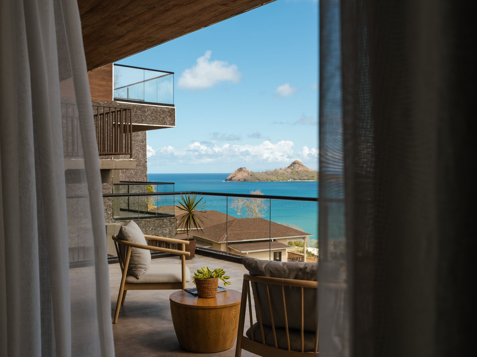 A luxury hotel balcony with elegant furniture overlooking a scenic natural landscape.