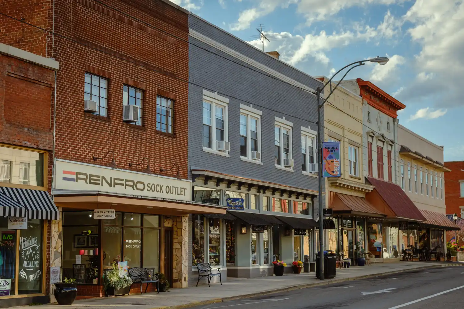 Historic storefronts including the Renfro Sock Outlet along the paved streets of downtown Mount Airy.