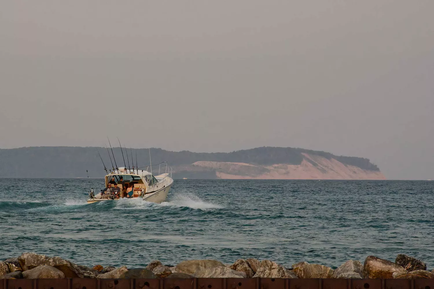 A motorboat creating a white wake on a deep blue lake in Leland, Michigan.