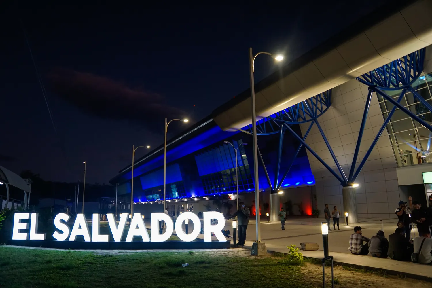 The contemporary architecture of El Salvador International Airport illuminated at night.