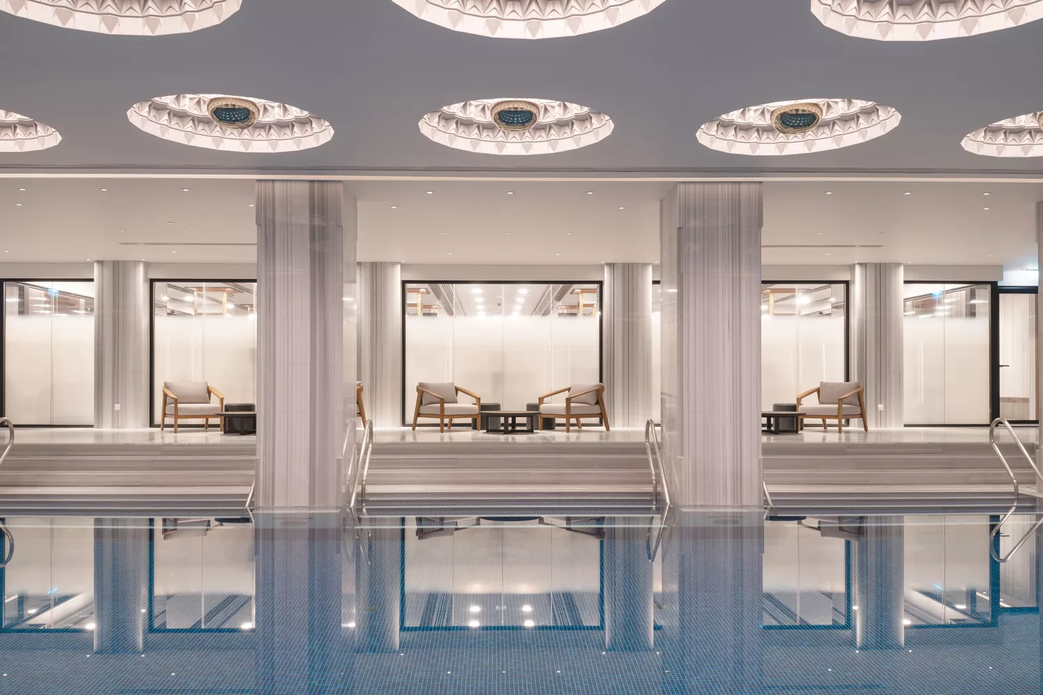 The architectural indoor spa pool at The Peninsula Istanbul featuring dramatic lighting and sleek stone finishes.