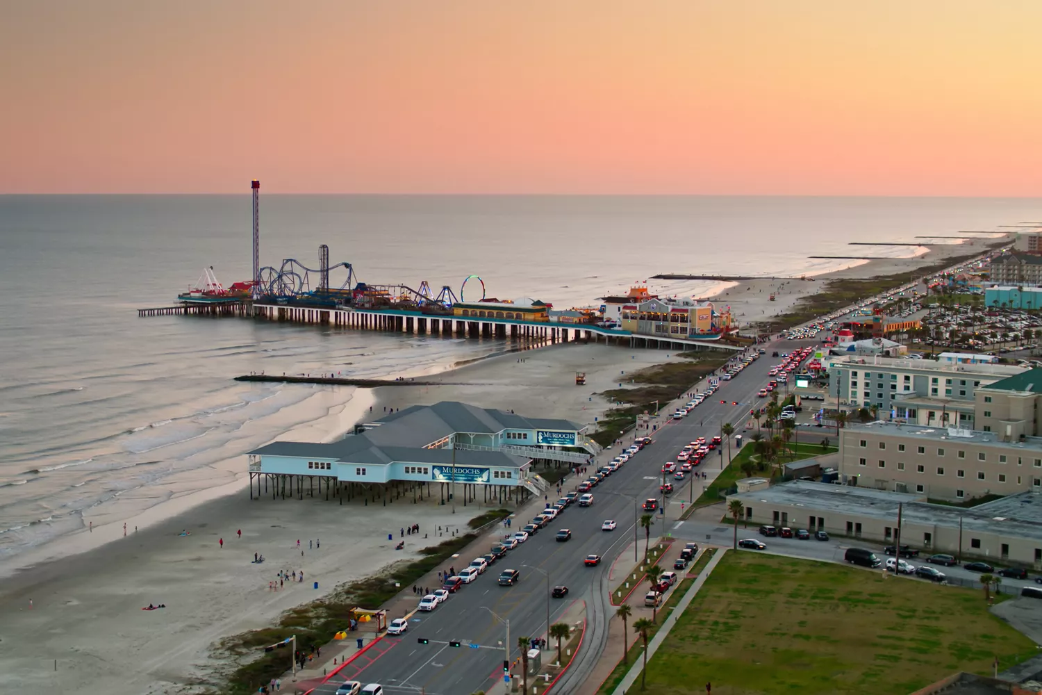 Wide drone shot showing the Galveston beachfront and the expanse of the Gulf Coast.
