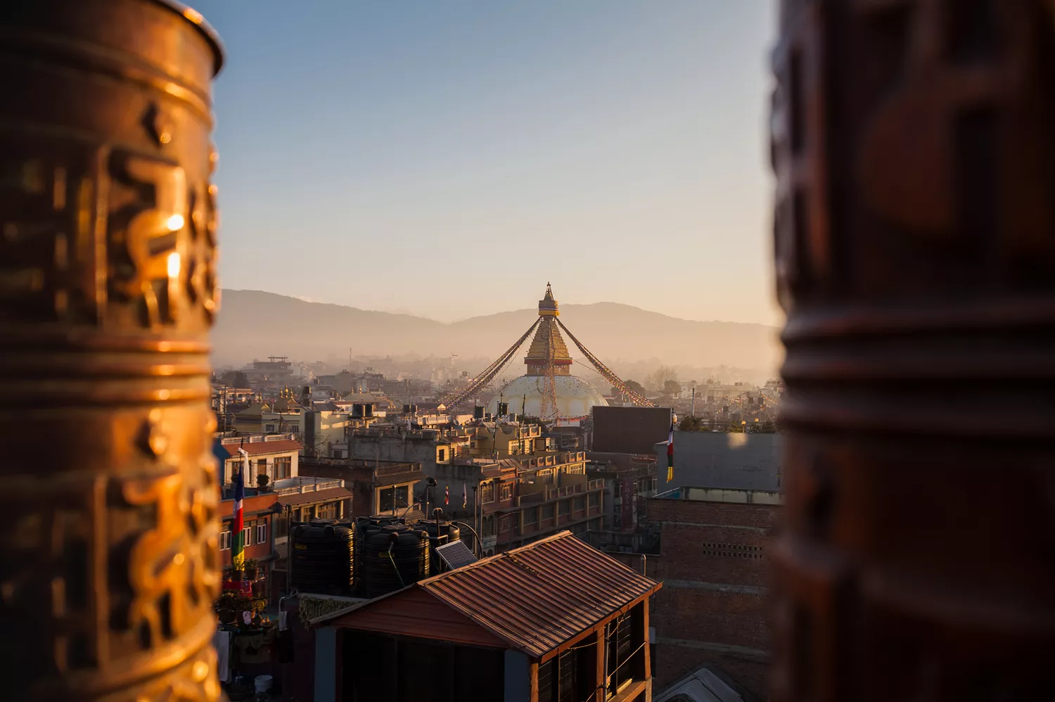 The white dome and golden spire of Boudhanath Stupa in Kathmandu under a clear sky.