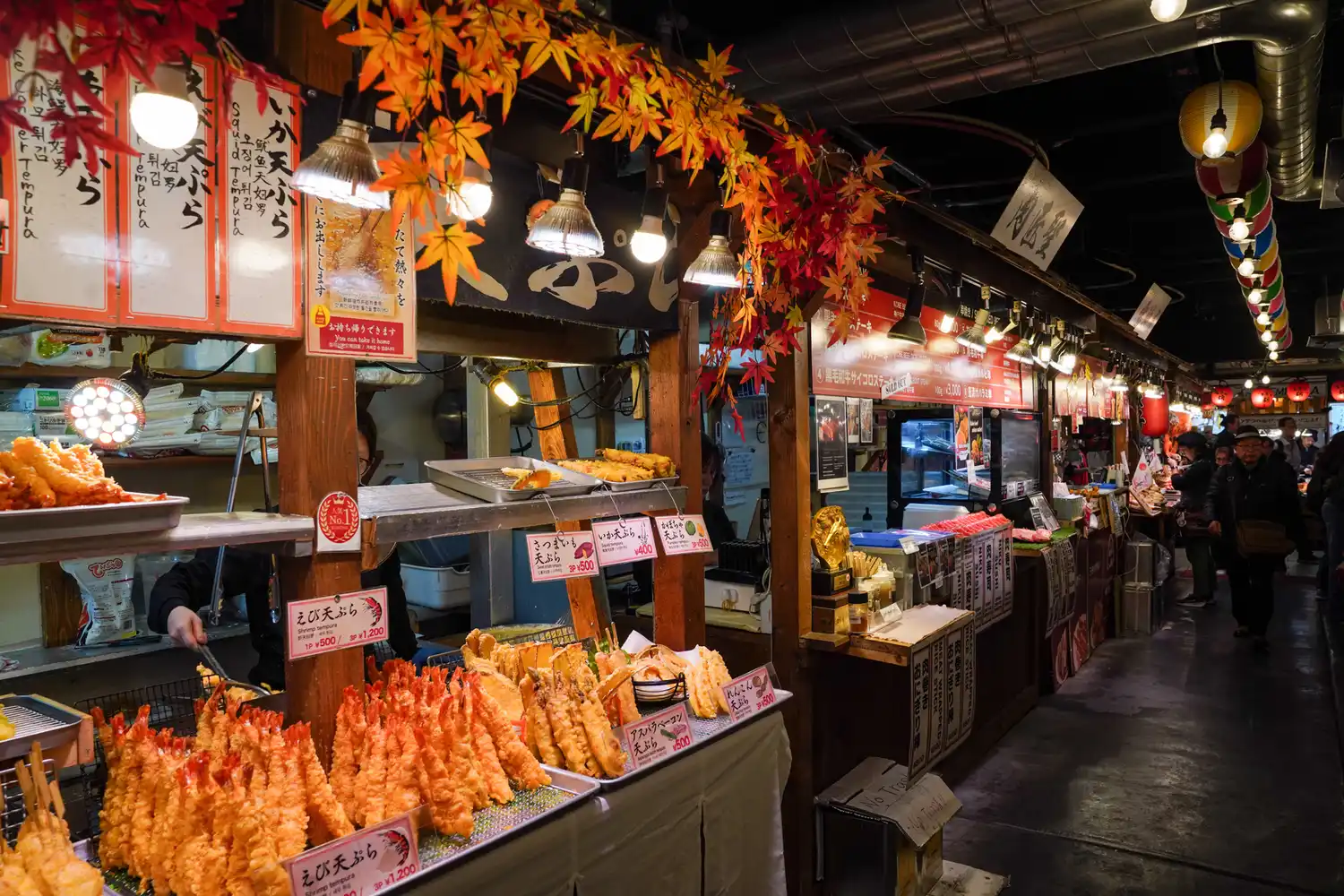 A vibrant food stall at Nishiki Market showcasing various Japanese snacks under colorful decorations.