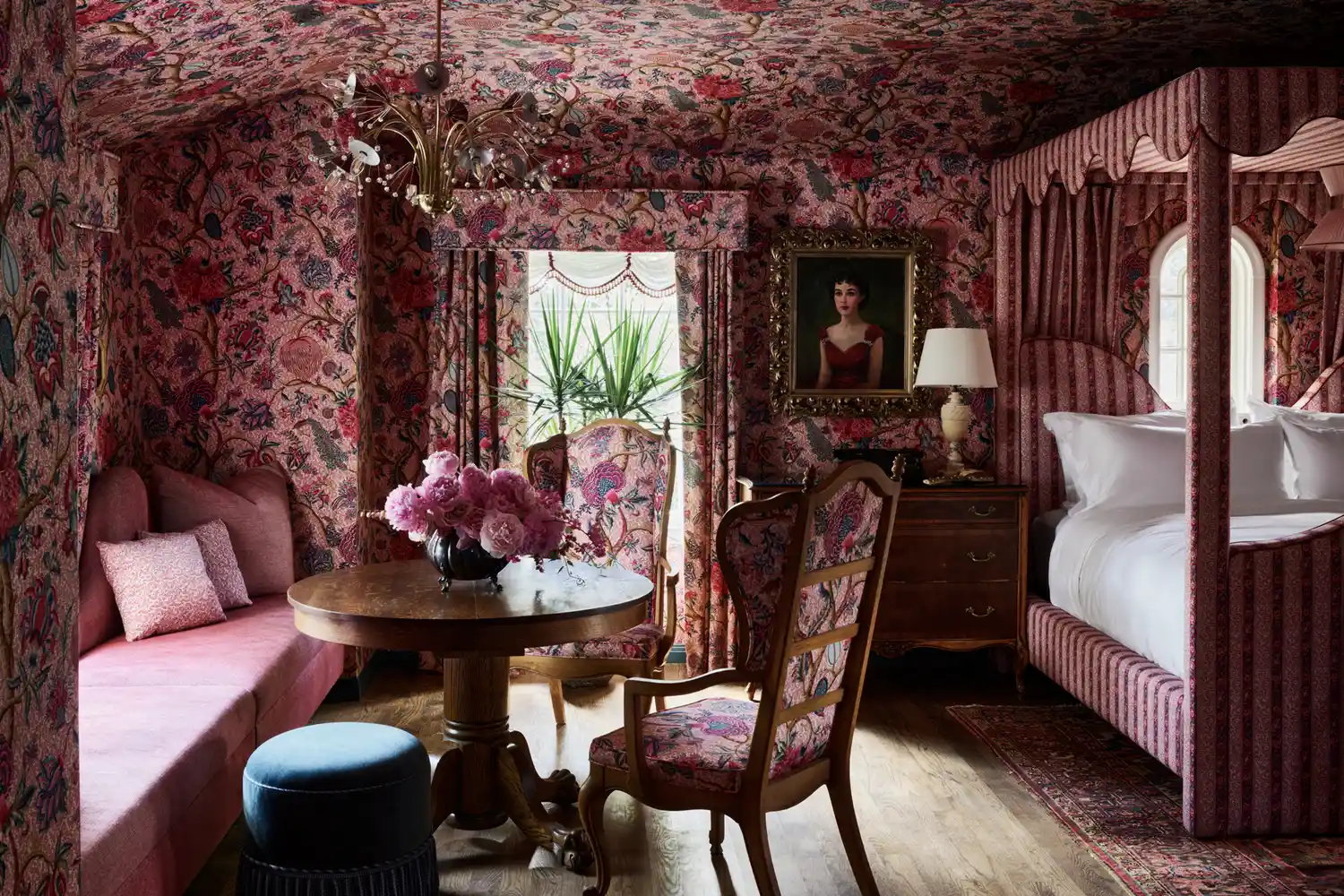 A pink guest room at Commodore Perry Estate with a canopy bed and ornate wallpaper.
