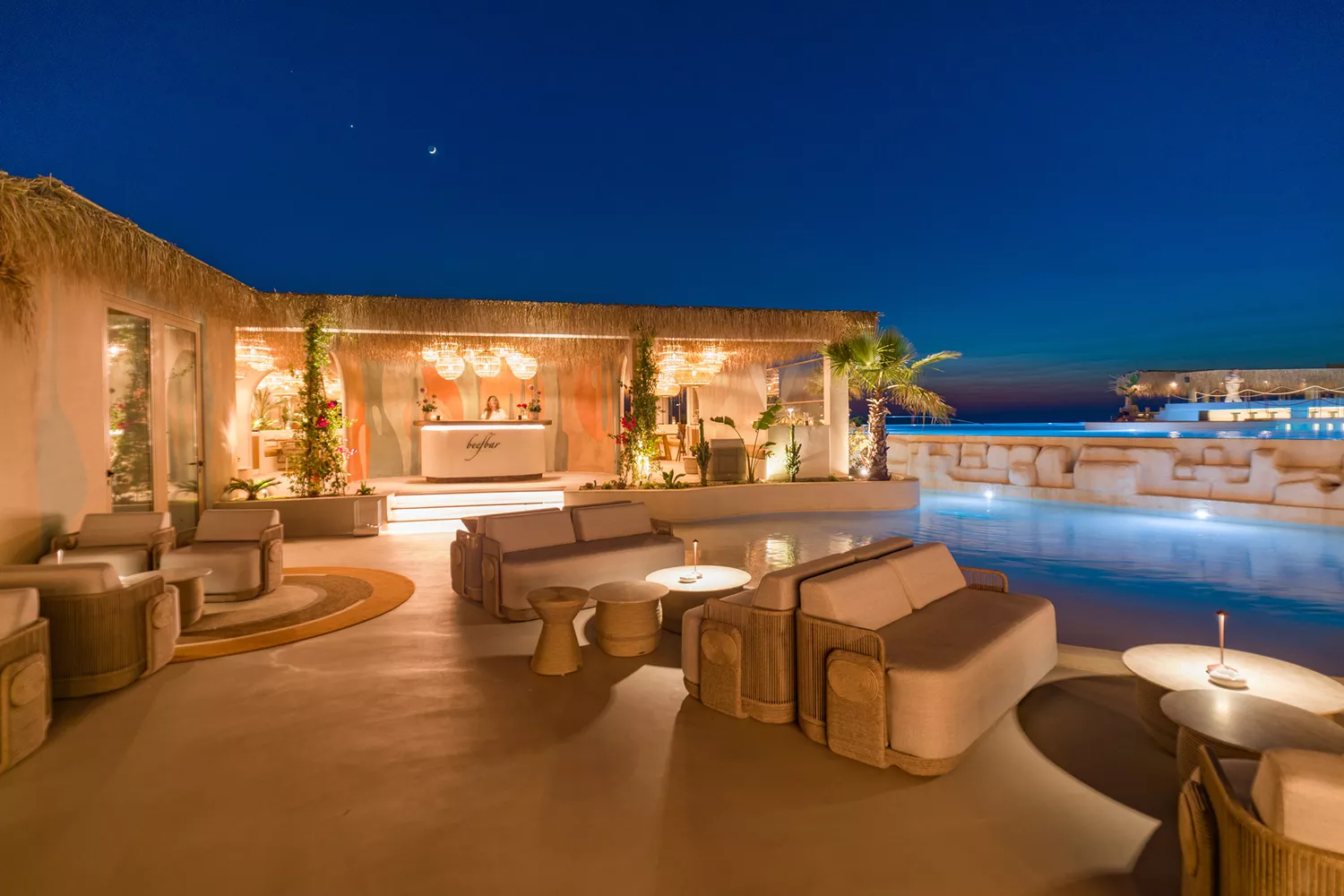 The outdoor dining setup at Beefbar Santorini during the golden hour sunset.