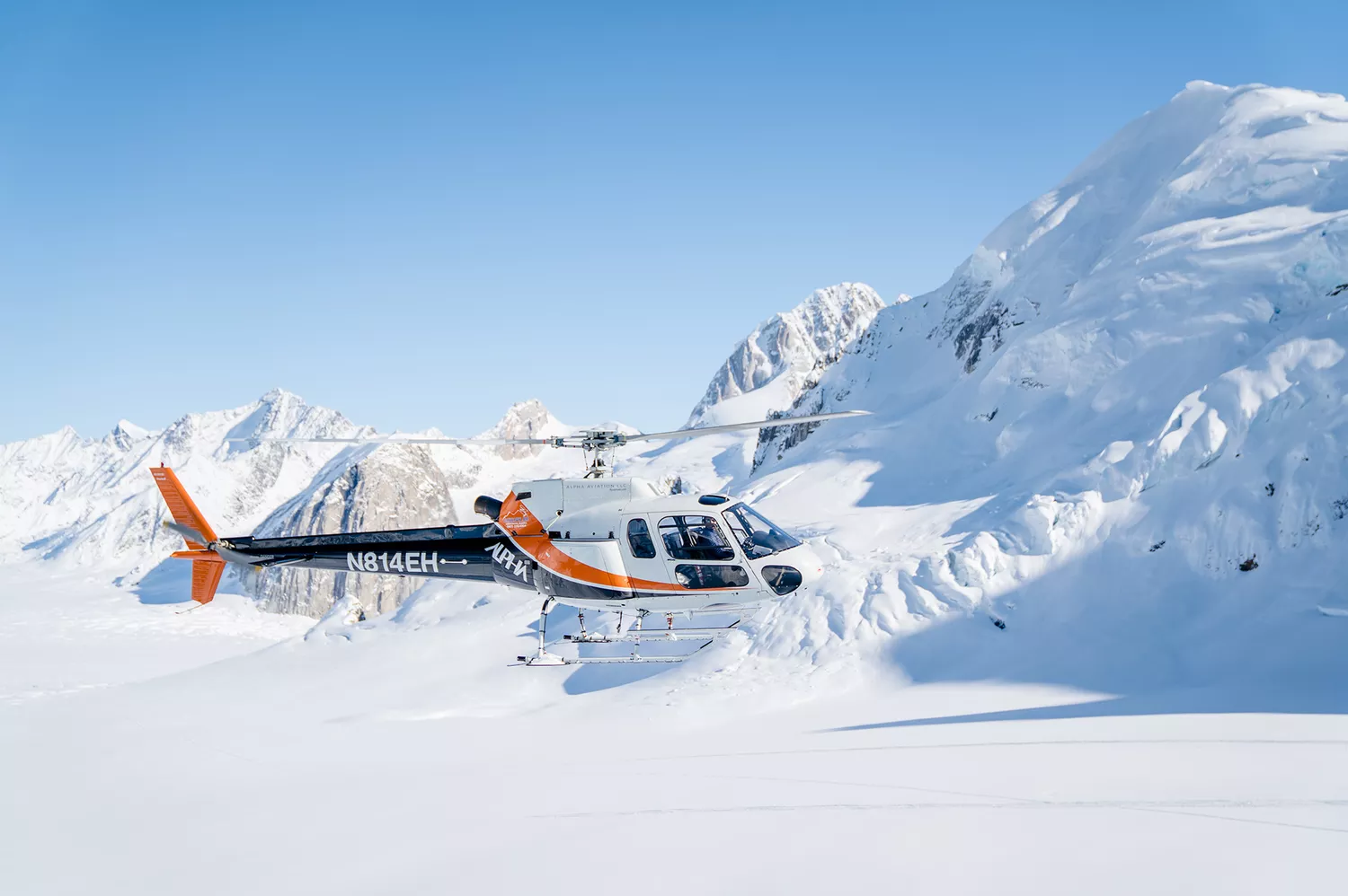 A private helicopter touching down on the snow-covered slopes adjacent to the Sheldon Chalet.