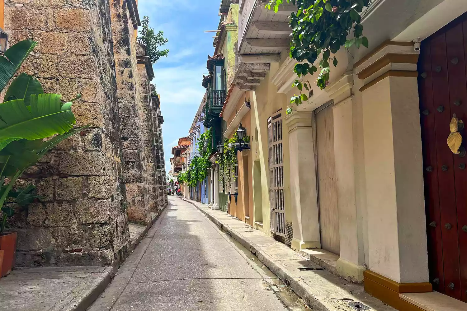A vibrant colonial street in Cartagena's historic center with colorful buildings.
