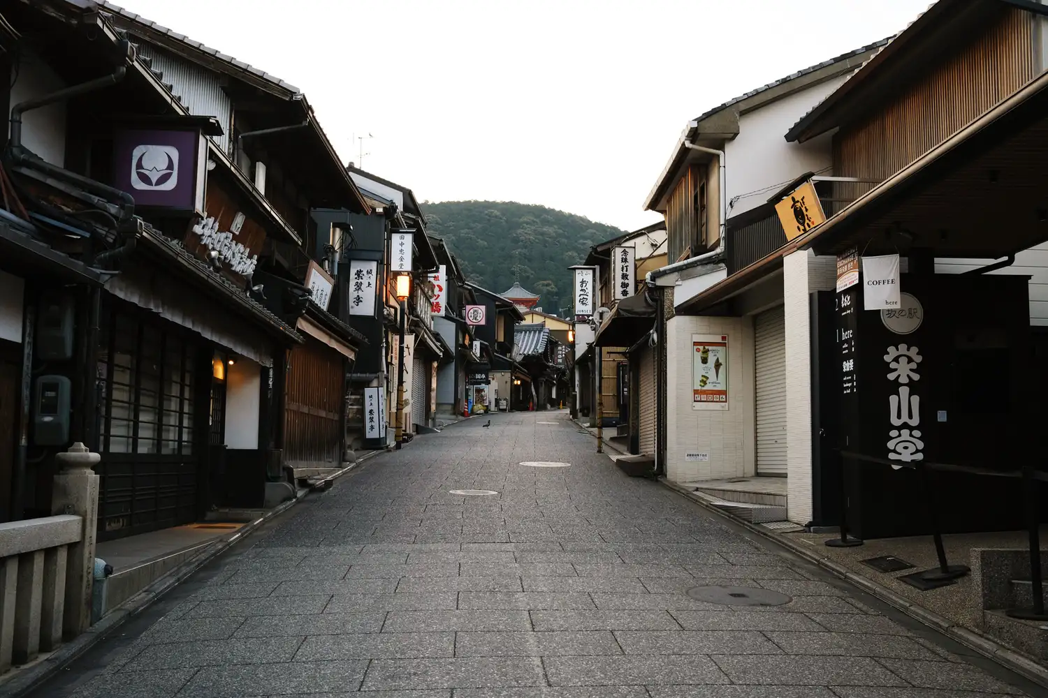 Traditional wooden machiya houses along a clean, quiet street in Kyoto.