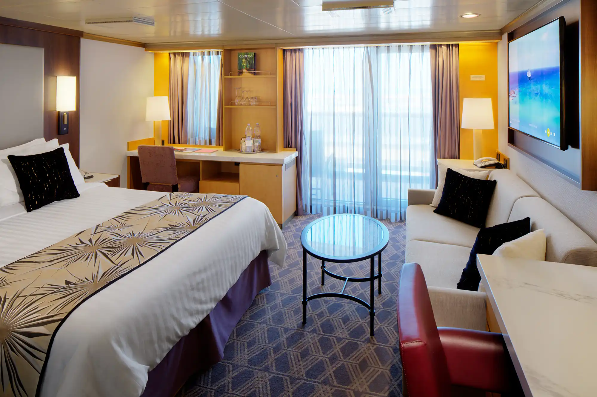 A modern and spacious bedroom suite onboard the MS Westerdam featuring clean lines and warm lighting.