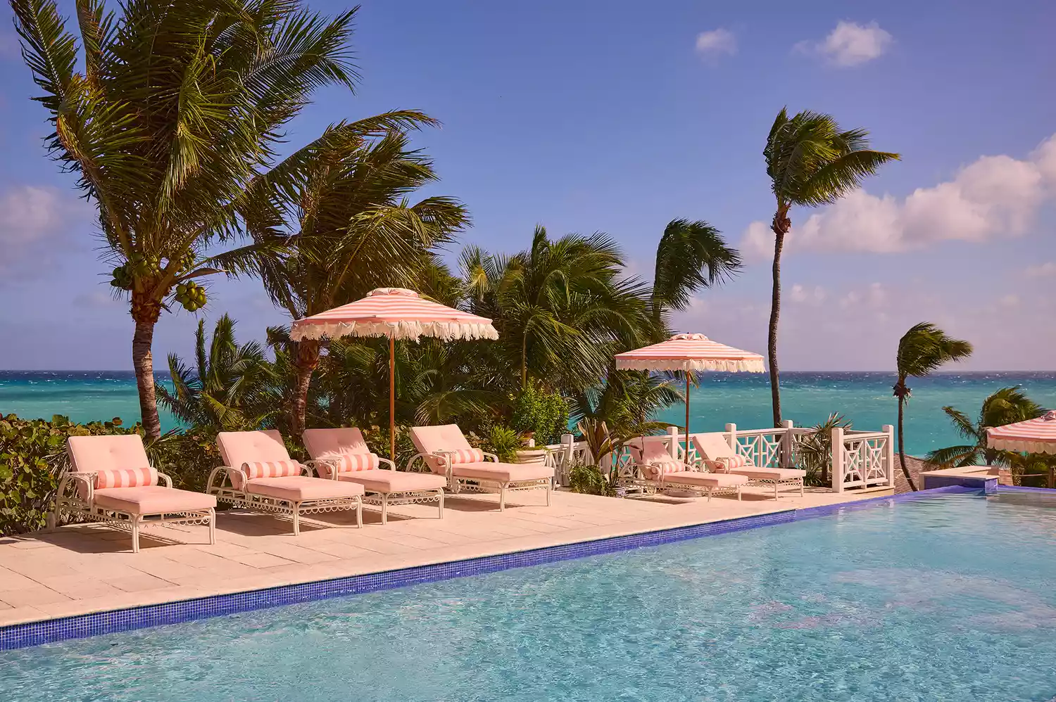 The swimming pool area at Coral Sands with lounge chairs and ocean views.
