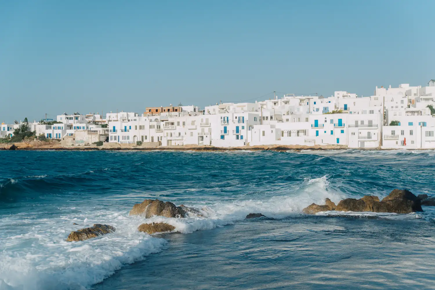 Classic white houses along the blue coastline of Paros, Greece.