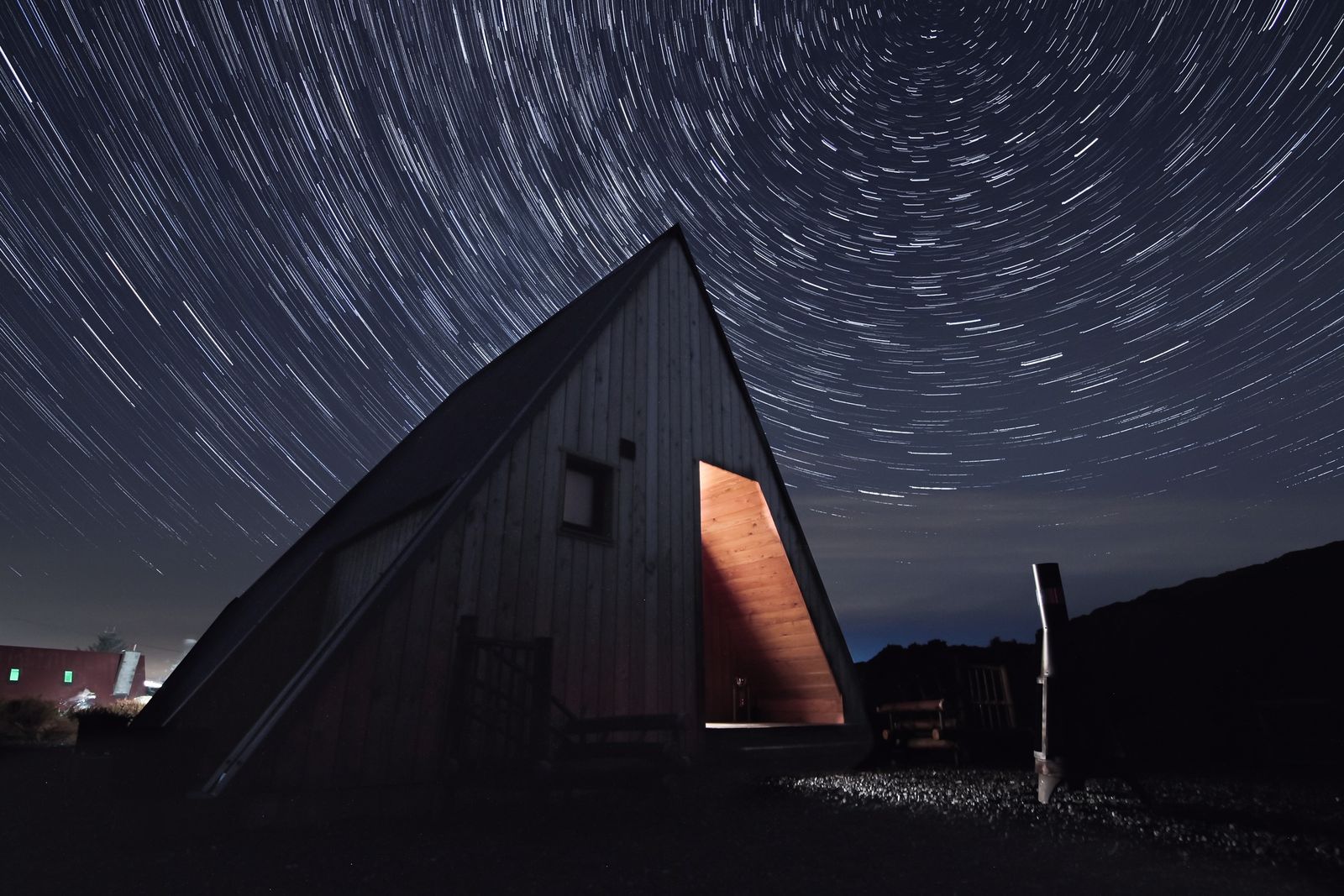 A rustic barn structure under a vivid starry night sky in the Irish countryside.