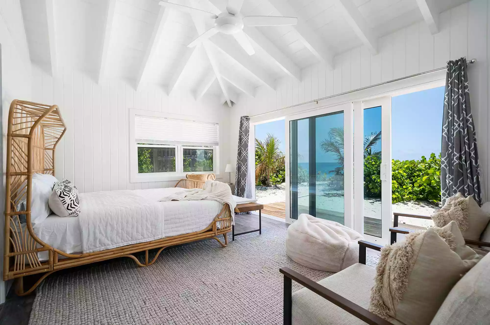 Luxury cottage bedroom with clean white linens and coastal wooden accents.