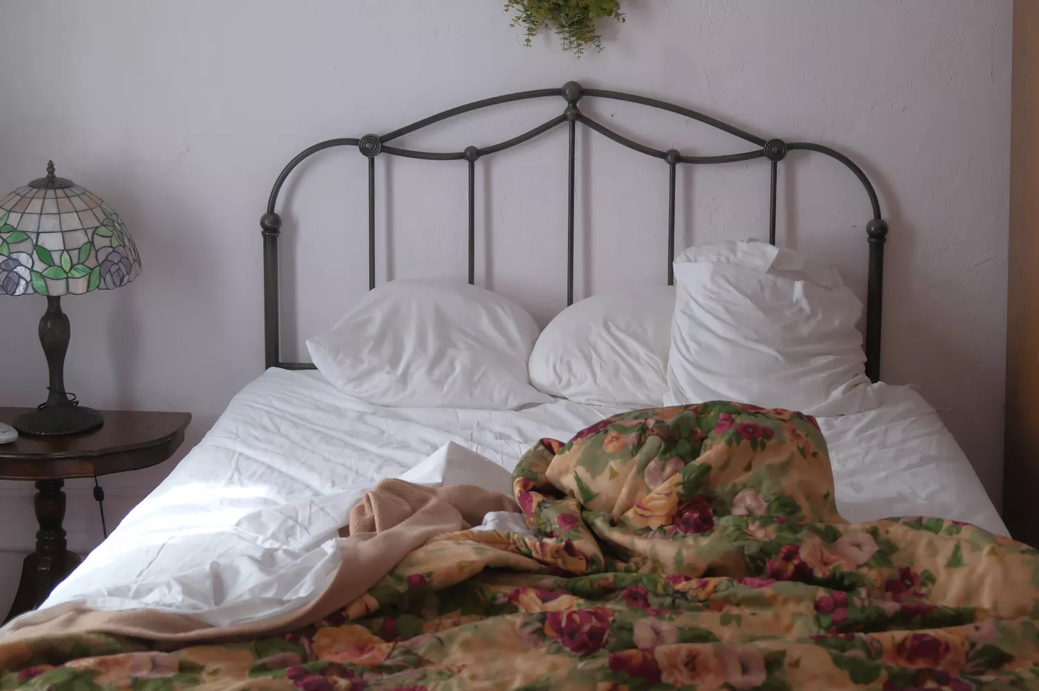 Interior of a Victorian-era guest room at the Jackson House Hotel with floral wallpaper and period furniture.