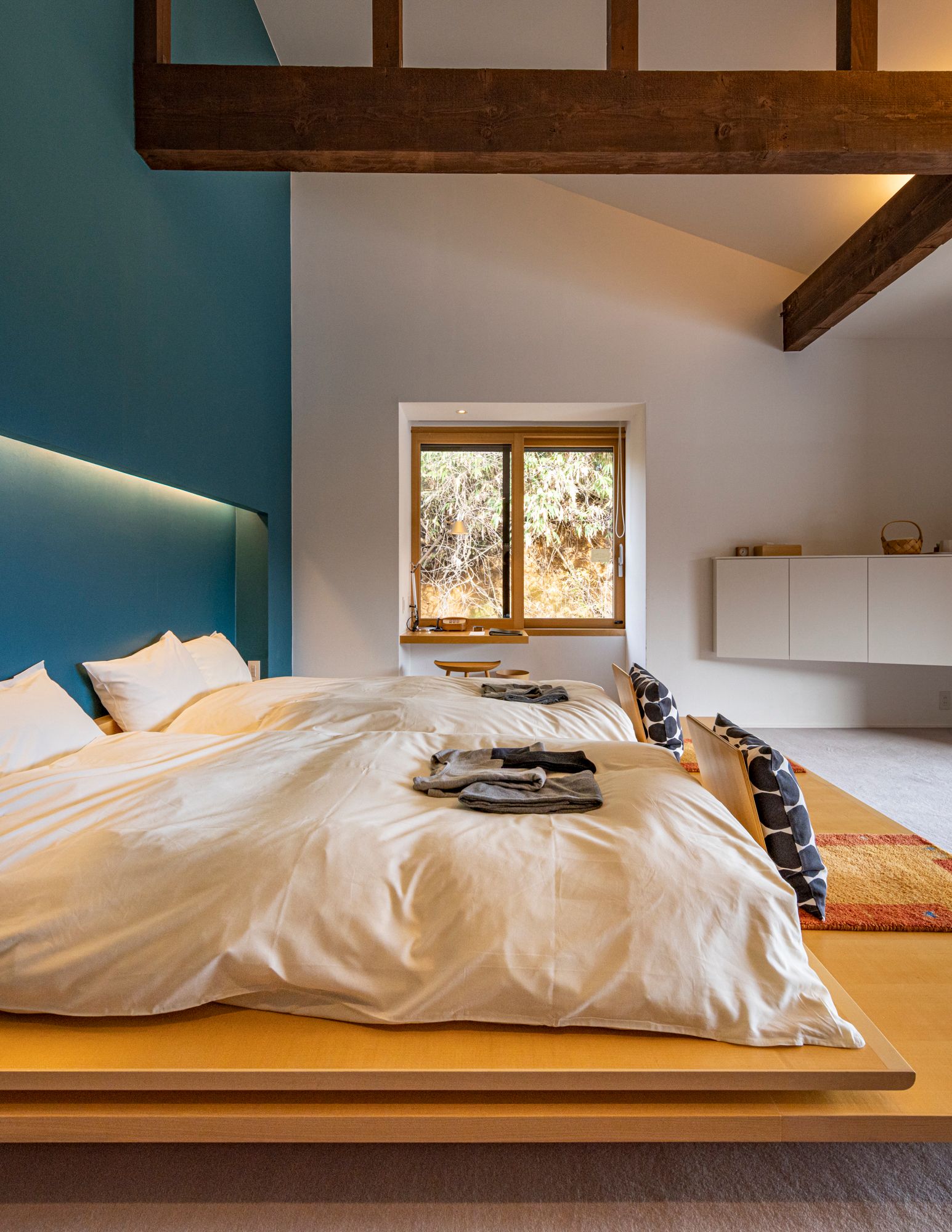 A modern and cozy bedroom interior with neutral tones and comfortable bedding.