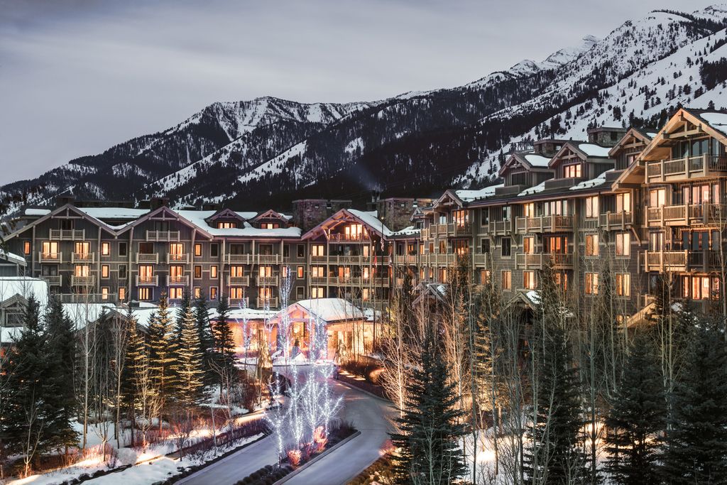 The exterior of the Four Seasons Resort Jackson Hole nestled at the base of the mountains.