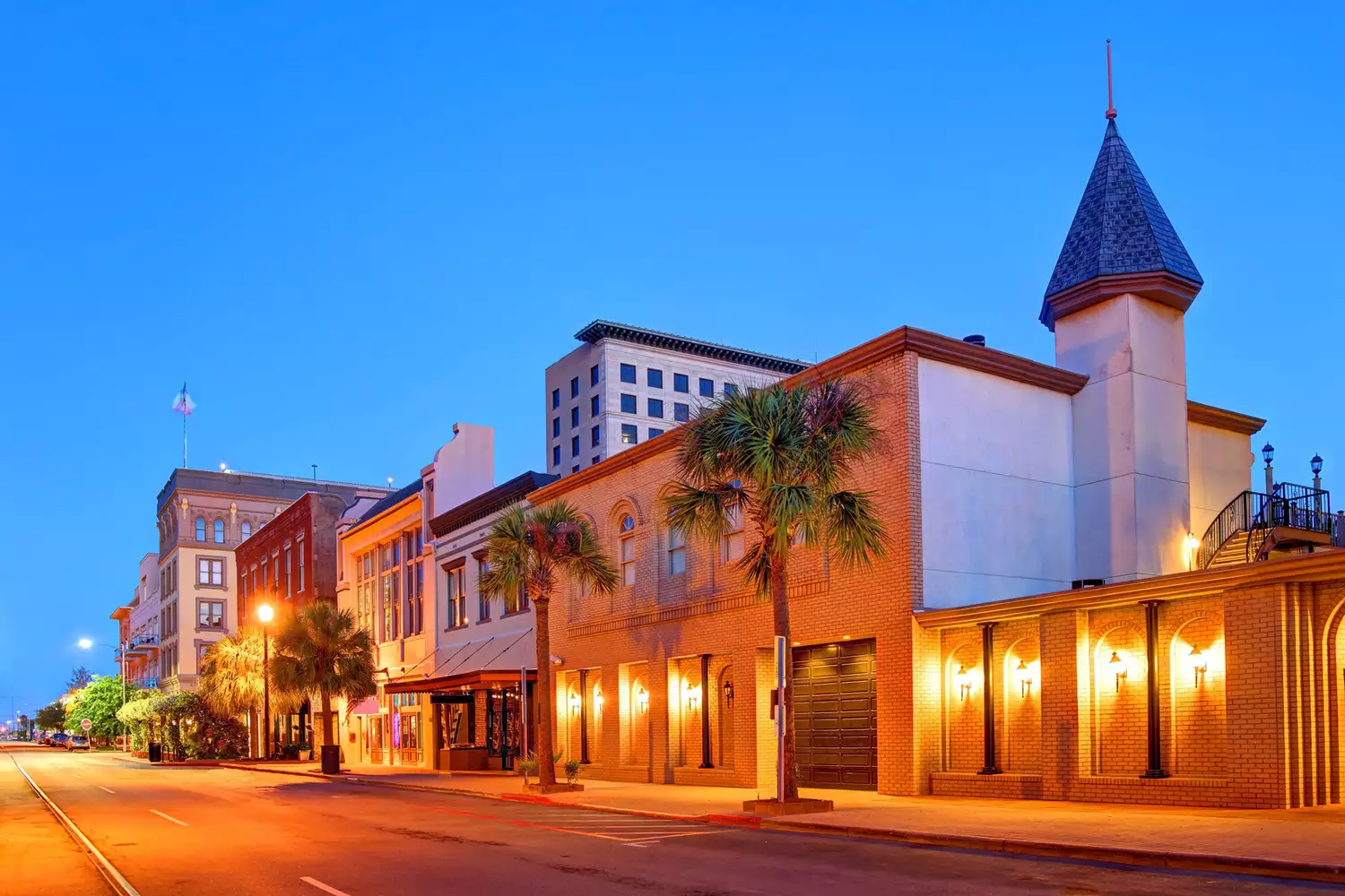 Preserved historic iron-front buildings in downtown Galveston illuminated at night.