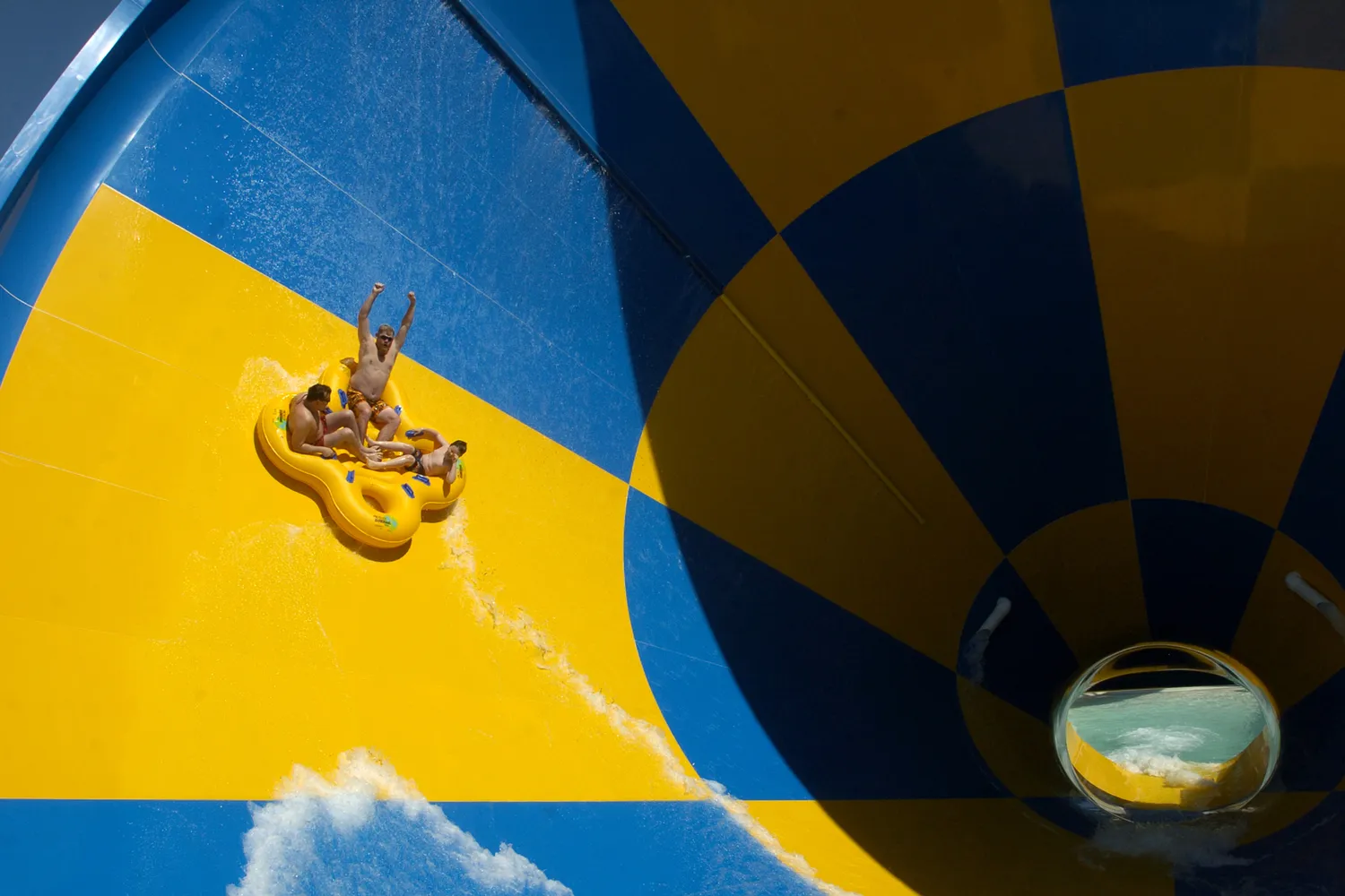 Visitors riding a large funnel water slide at a Texas water park.