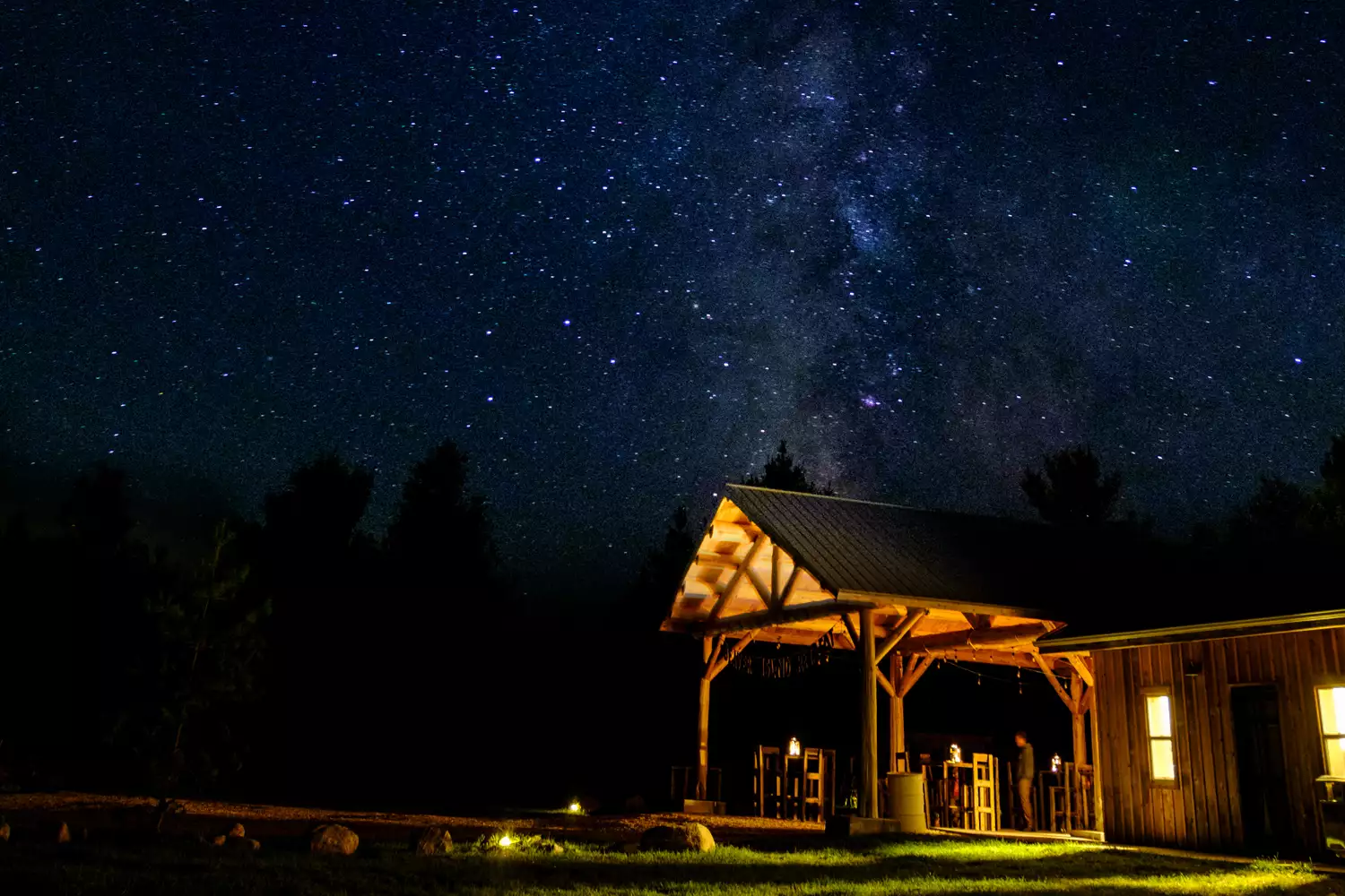 A glamping pavilion at Beaver Island Retreat illuminated from within under a starry night sky.