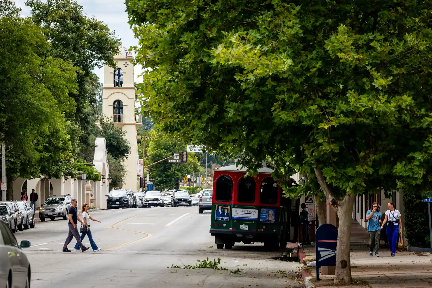 A scenic street in downtown Ojai featuring Spanish-style architecture and the local trolley.