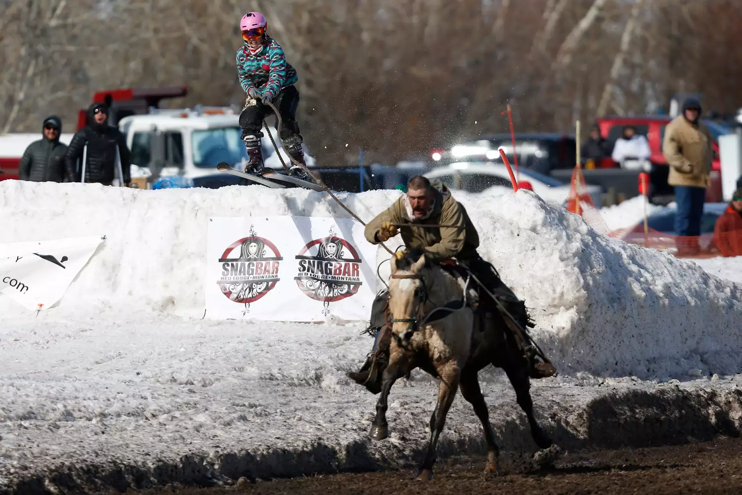 A skier being pulled by a horse at high speed during a skijoring race in Red Lodge.