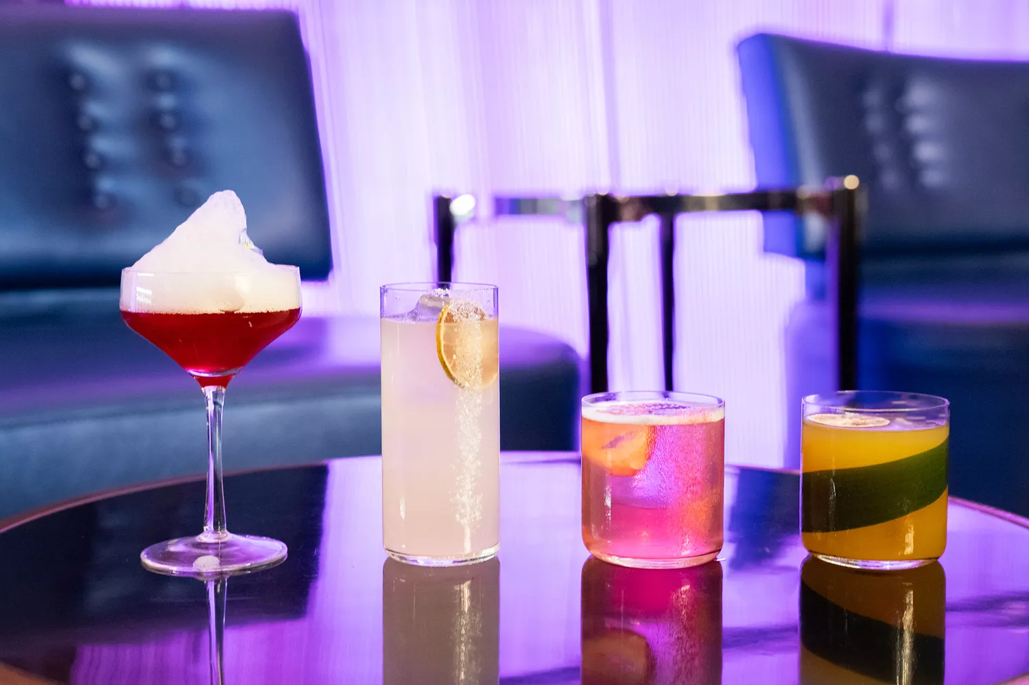 A flight of artisanal cocktails from the new Chandelier menu displayed on a bar top.