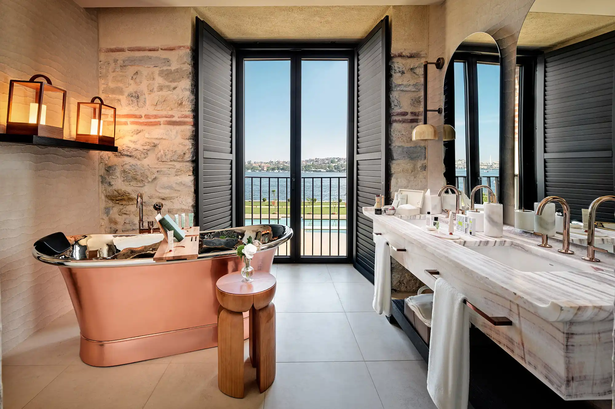 Luxurious bathroom with a standalone soaking tub and floor-to-ceiling windows overlooking the Istanbul waterfront.