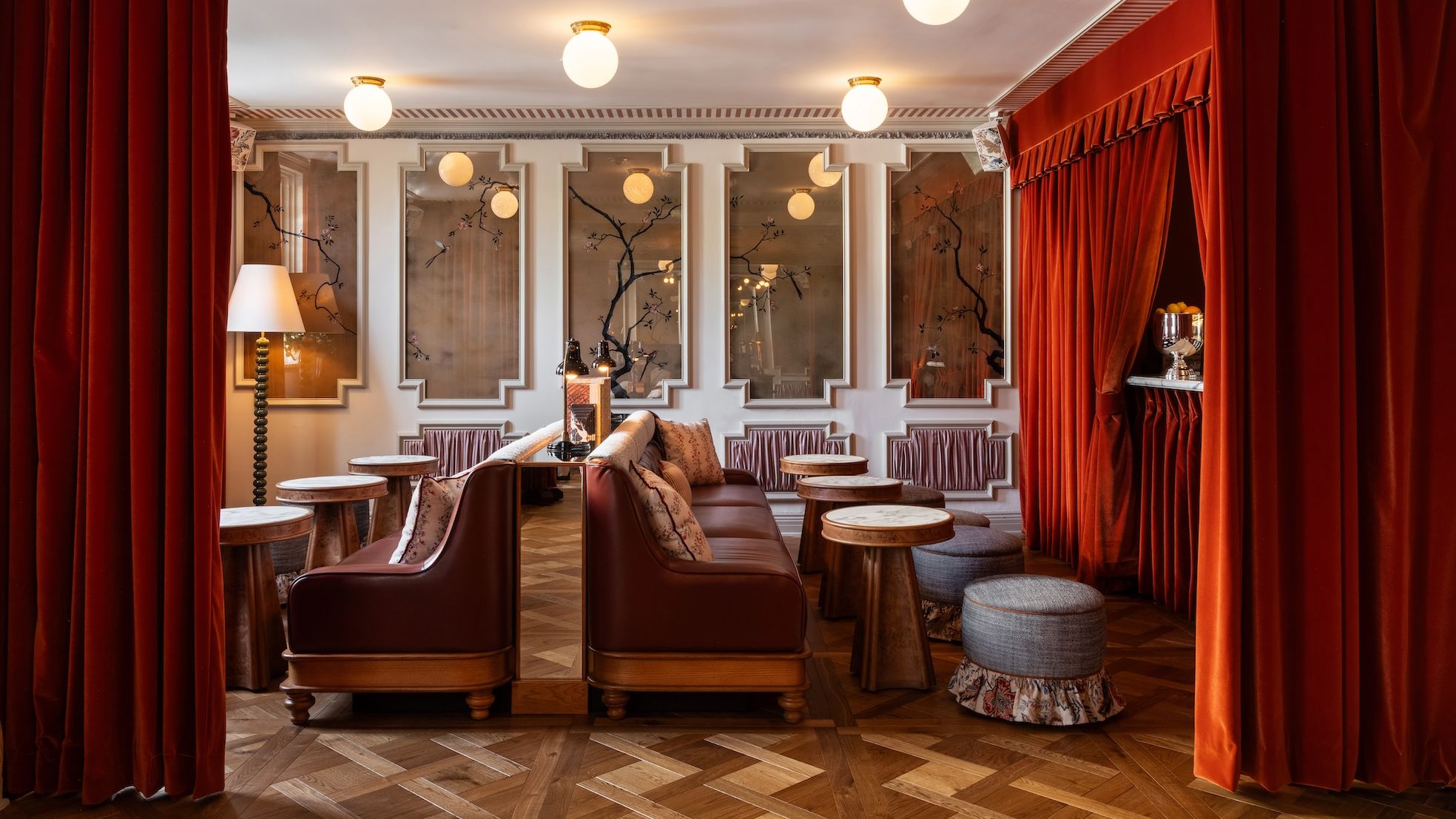 A grand hotel lobby with a glowing lamp, contemporary art, and plush seating areas.